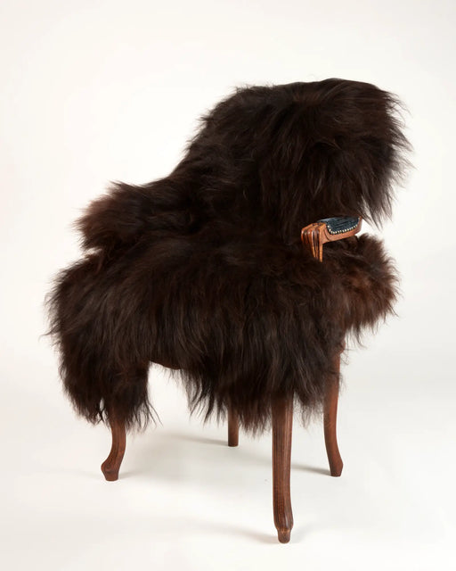 A very dark black brown Icelandic sheepskin rug ith long wool