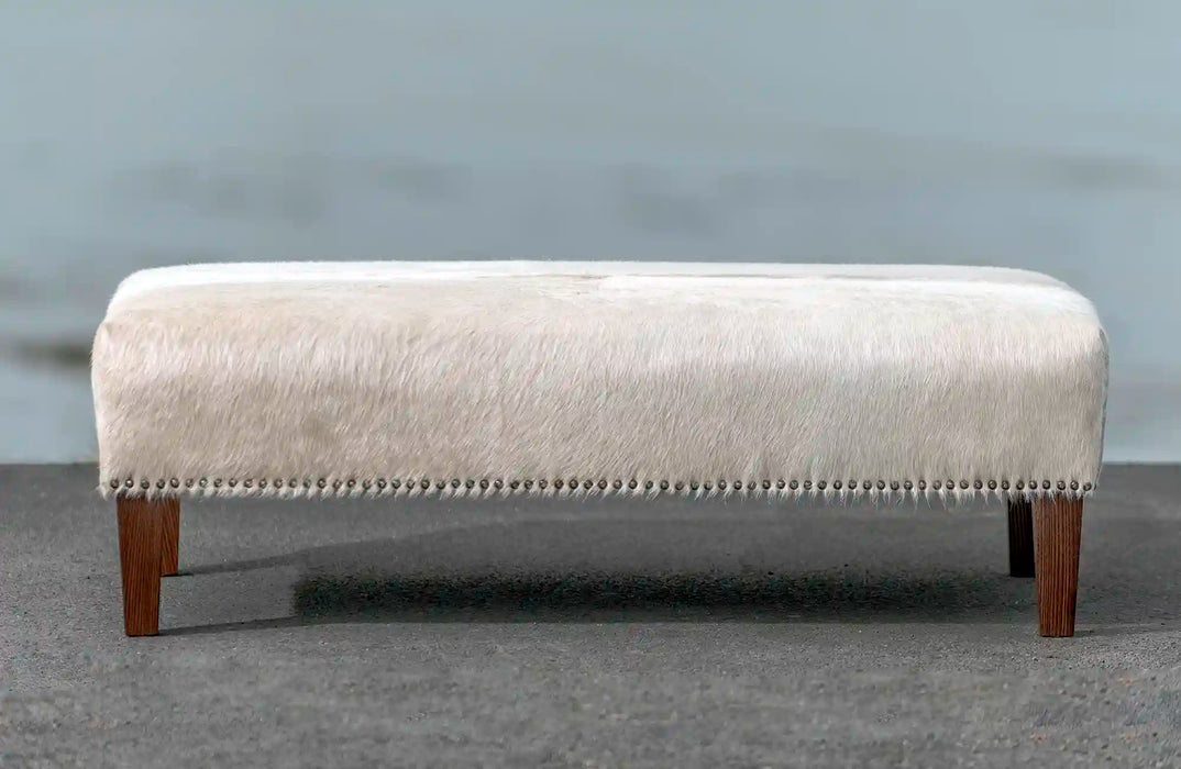 Light cowhide ottoman with studs