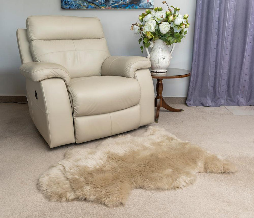 Stone beige sheepskin rug in front of armchair