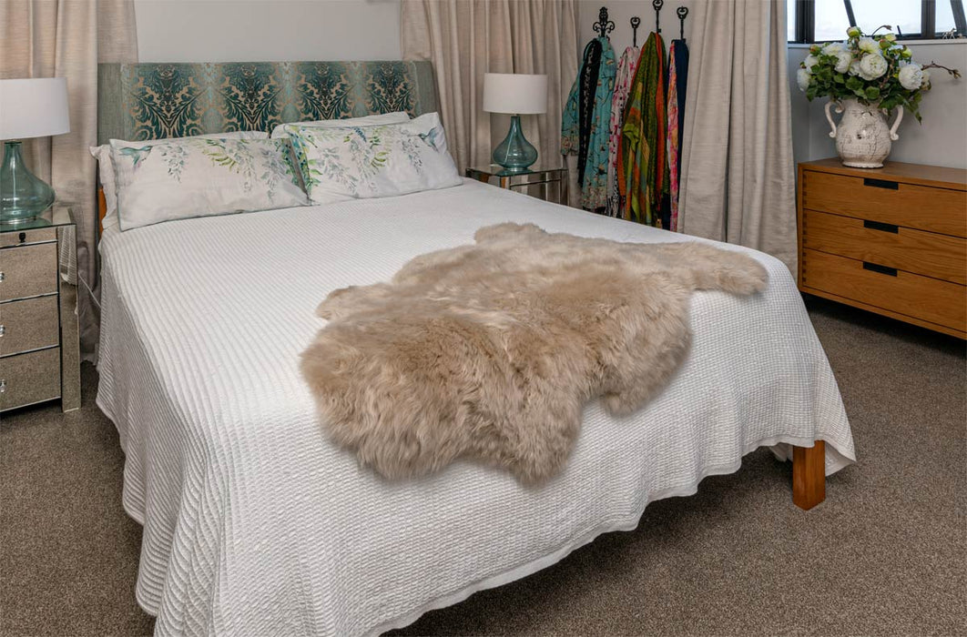 Stone beige sheepskin rug on bed